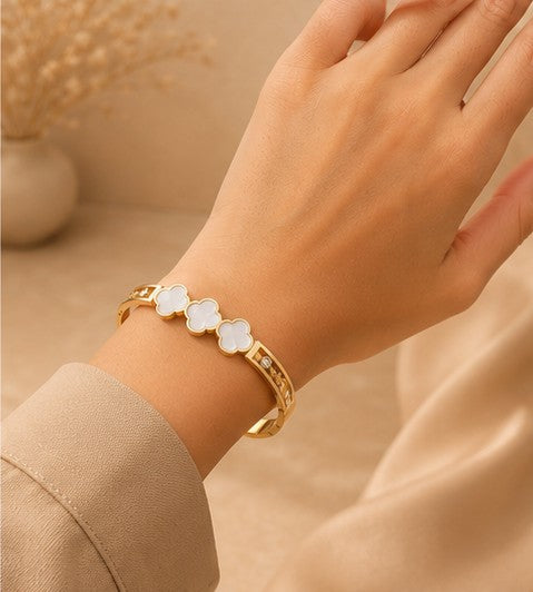 White clover gold bangle worn on wrist