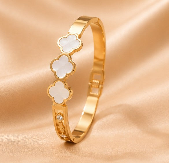 White clover gold bangle on satin background